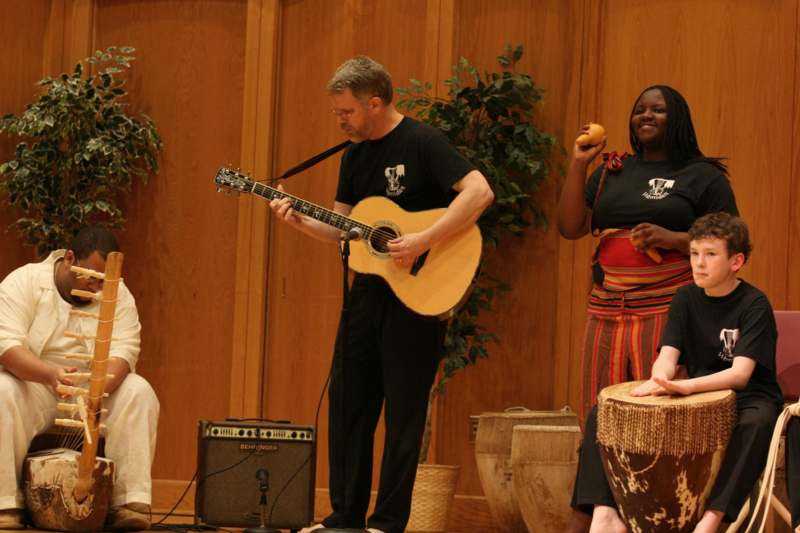 a man playing a guitar and a woman sitting on a stage