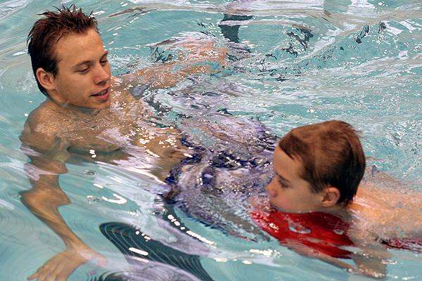 a man and child swimming in a pool