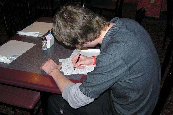a man writing on a piece of paper