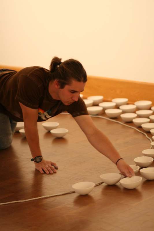 a man bending over a row of bowls