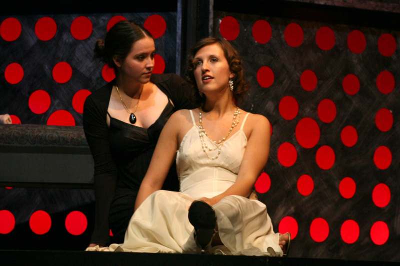 two women sitting on a stage