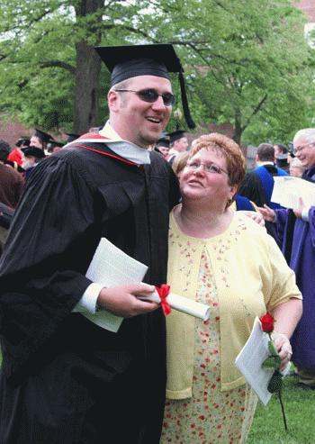 a man in a cap and gown with a woman in a graduation gown