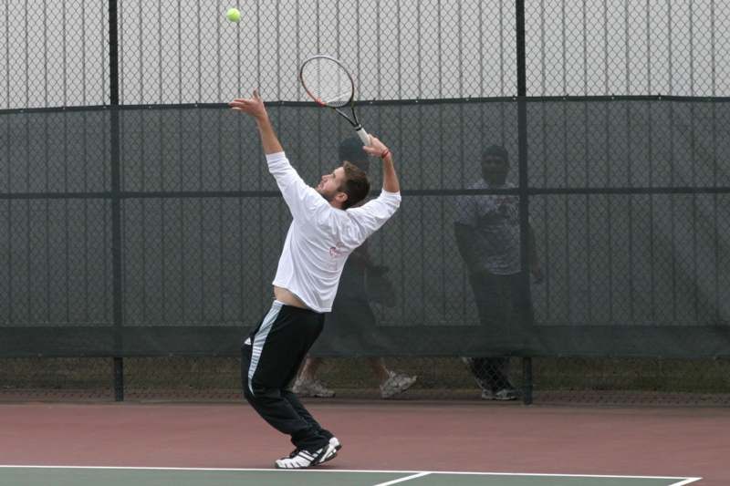 a man hitting a tennis ball with a racket