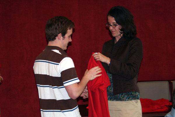 a man and woman holding a red shirt