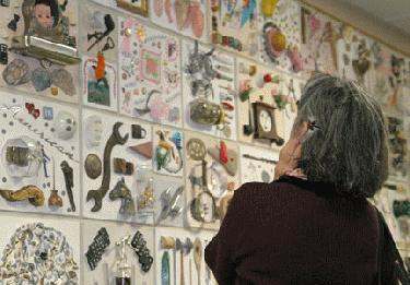 a woman looking at a wall of various objects