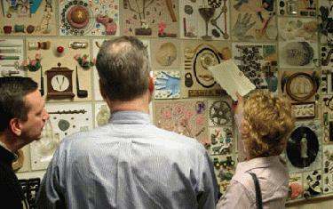 a man and woman looking at a wall with pictures