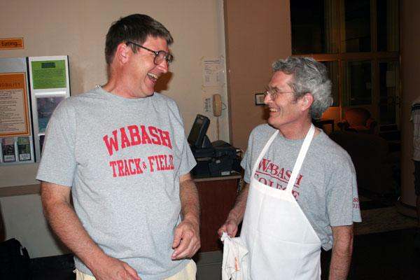 a couple of men wearing aprons laughing