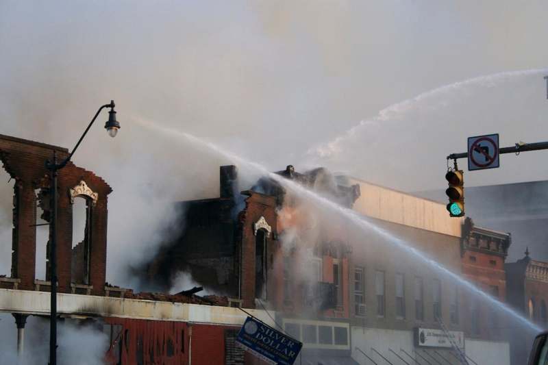 a firefighter spraying water on a building