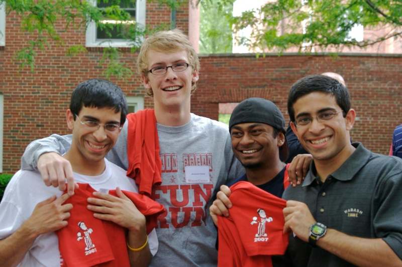 a group of young men holding up t-shirts