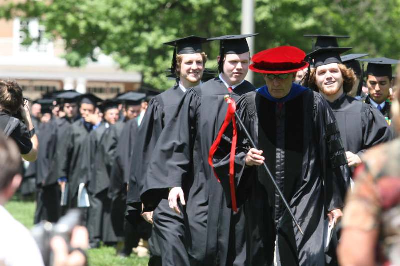 a group of people in graduation gowns and caps walking