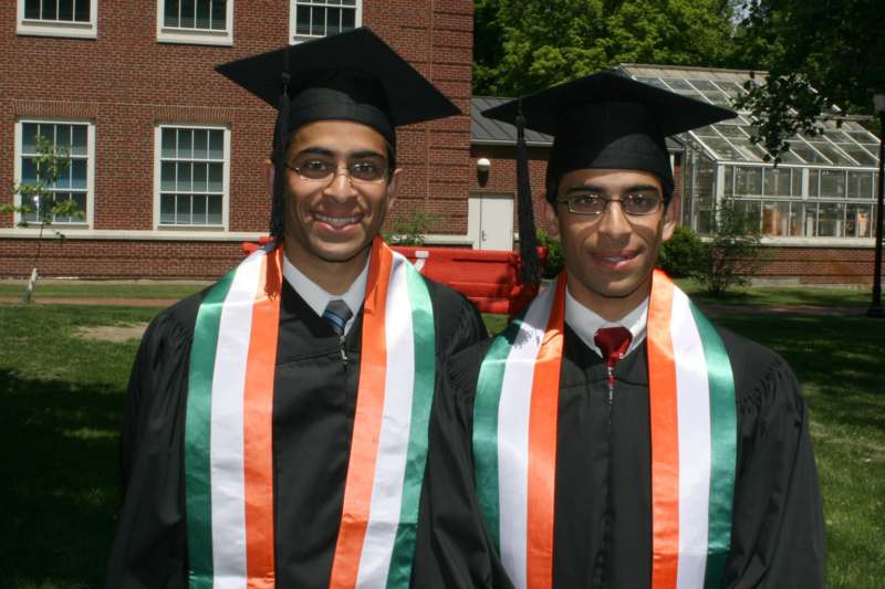 a couple of men wearing graduation gowns