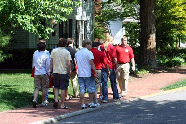 a group of people walking on a sidewalk