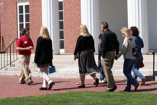 a group of people walking on a brick sidewalk