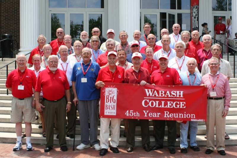 a group of men in red shirts and white shirts holding a banner