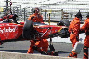 a group of people in orange jumpsuits holding a race car