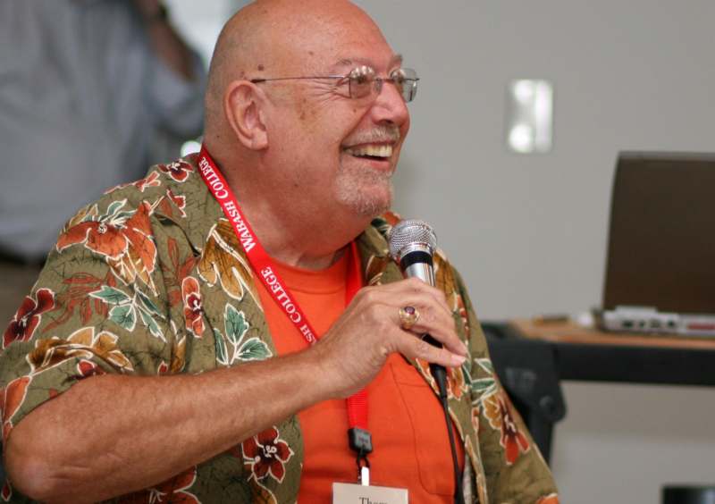 a man smiling at a microphone