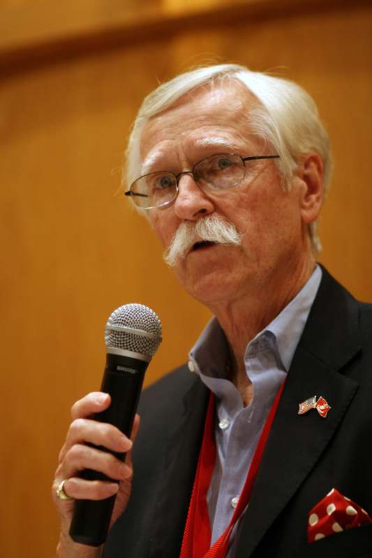a man with a mustache holding a microphone