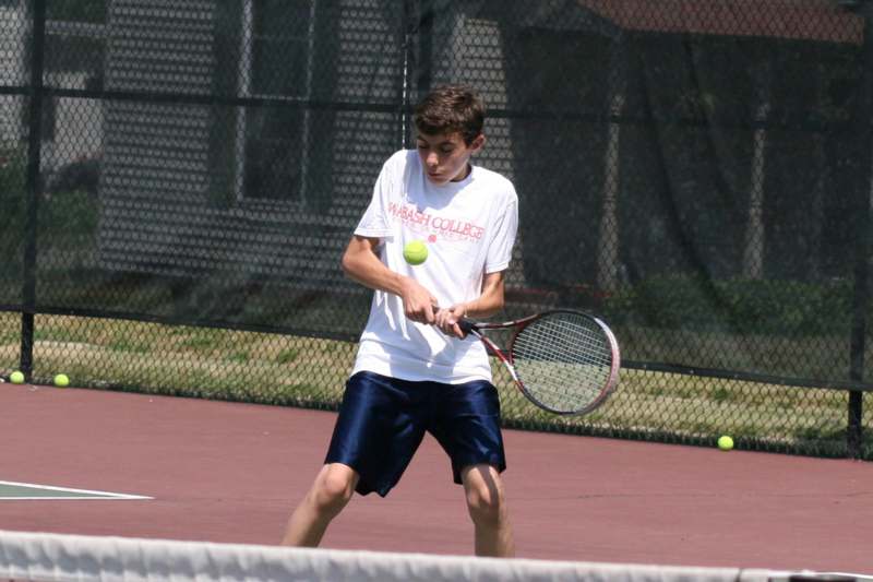 a boy playing tennis on a court
