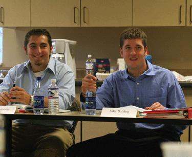 men sitting at a table with water bottles