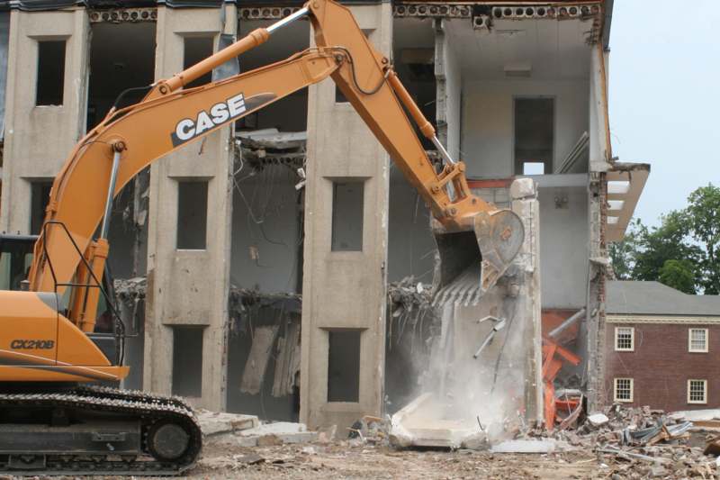 a construction vehicle digging into a building