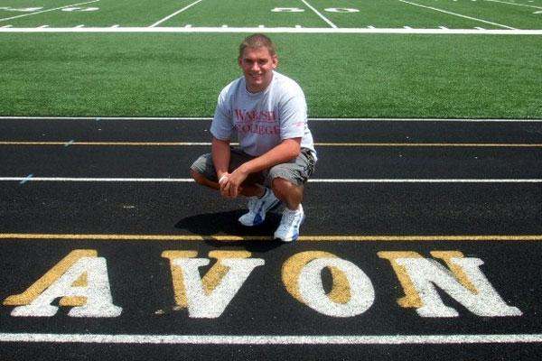 a man squatting on a football field