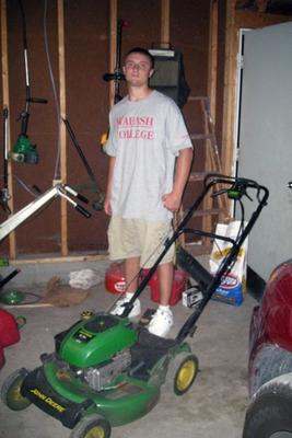 a man standing next to a lawnmower