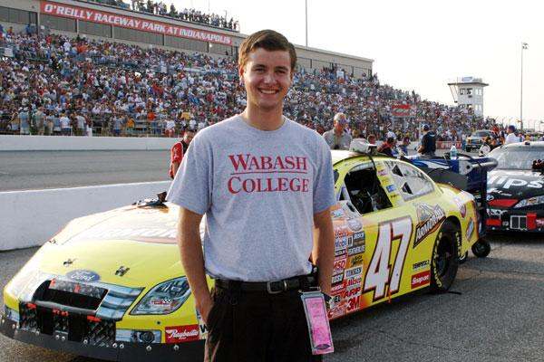 a man standing in front of a race car