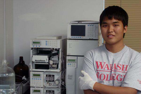 a young man standing in front of several white machines