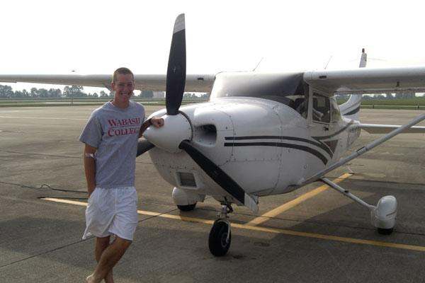 a man standing next to a propeller plane
