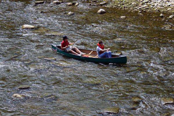 a couple of people rowing a canoe