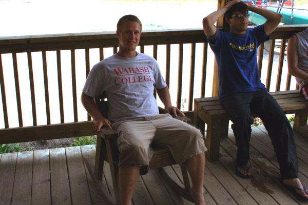 a man sitting on a wooden chair
