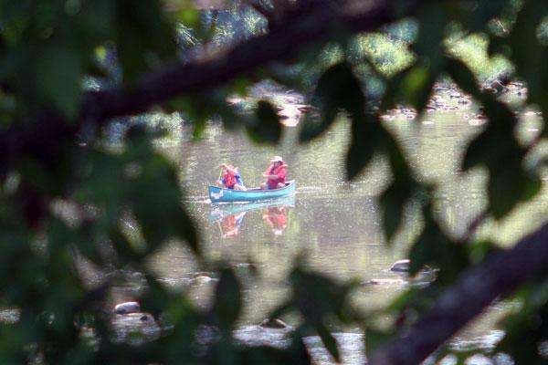 a couple of people in a canoe on a lake