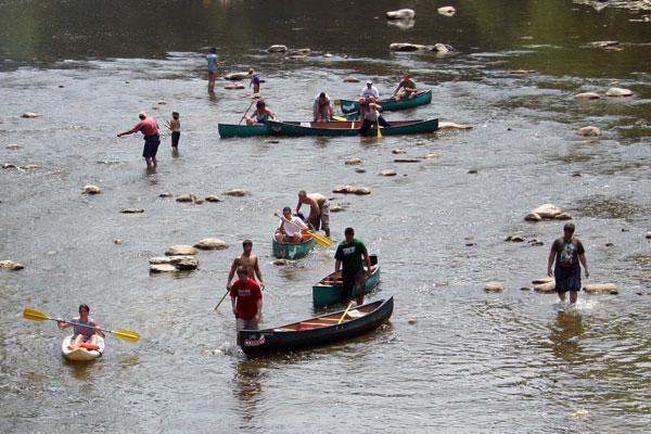 a group of people in canoes in a river