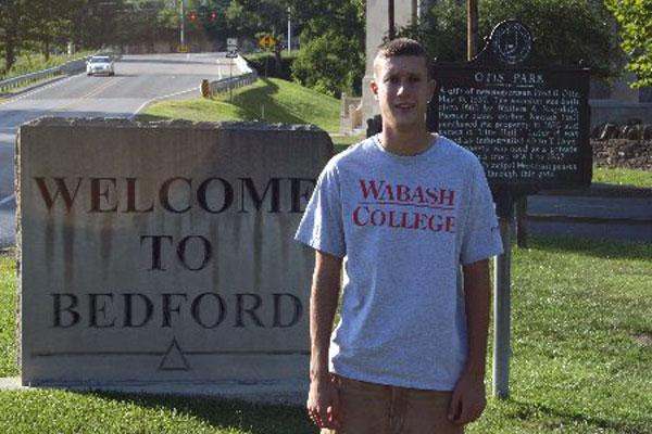 a man standing in front of a sign