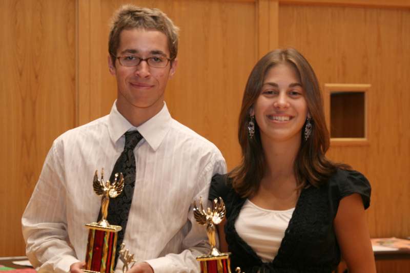 a man and woman holding trophies