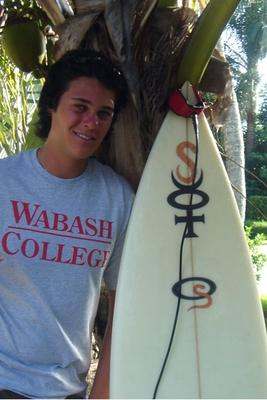 a man standing next to a surfboard