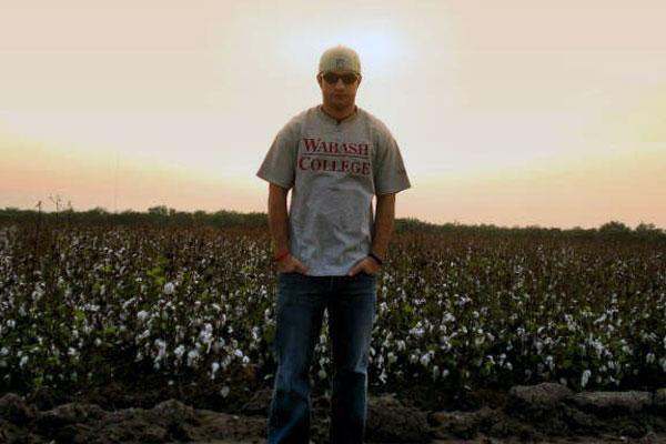 a man standing in a field of cotton