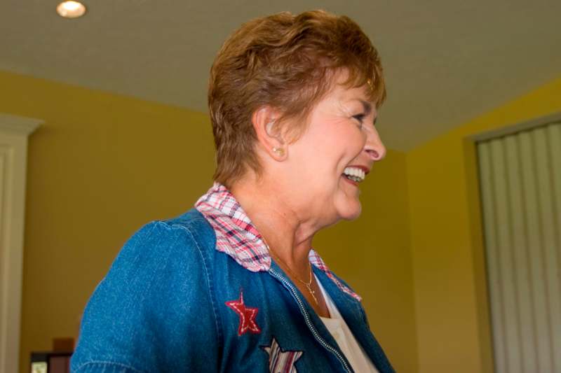 a woman smiling in a blue jacket