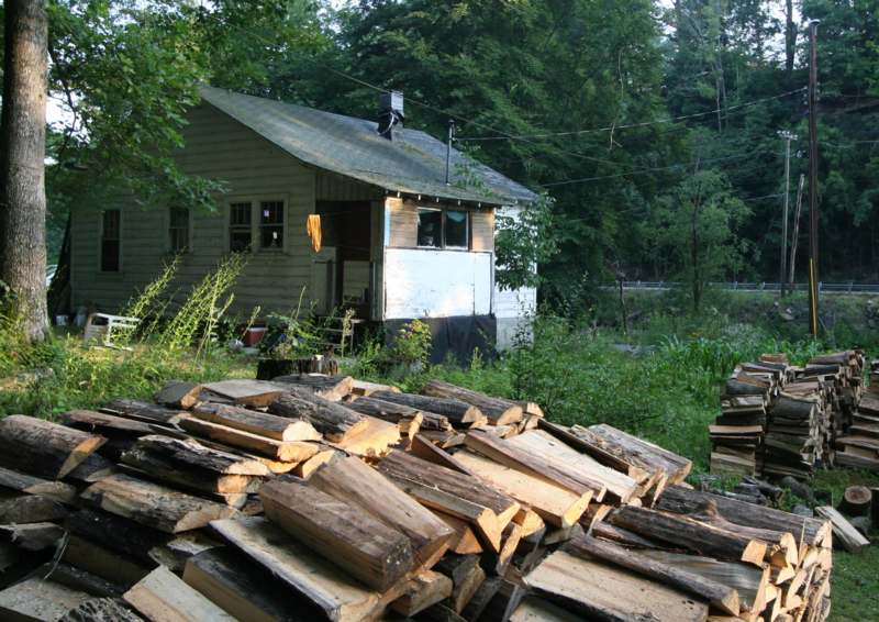 a pile of cut wood in front of a house