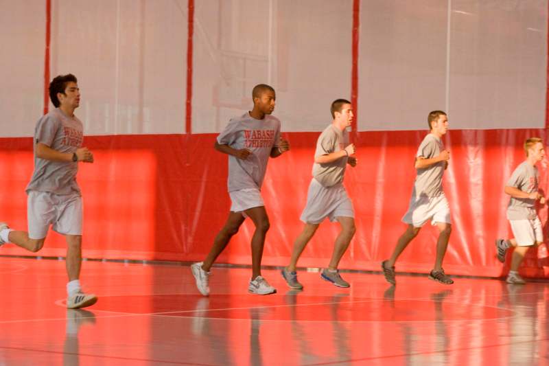a group of men running on a court