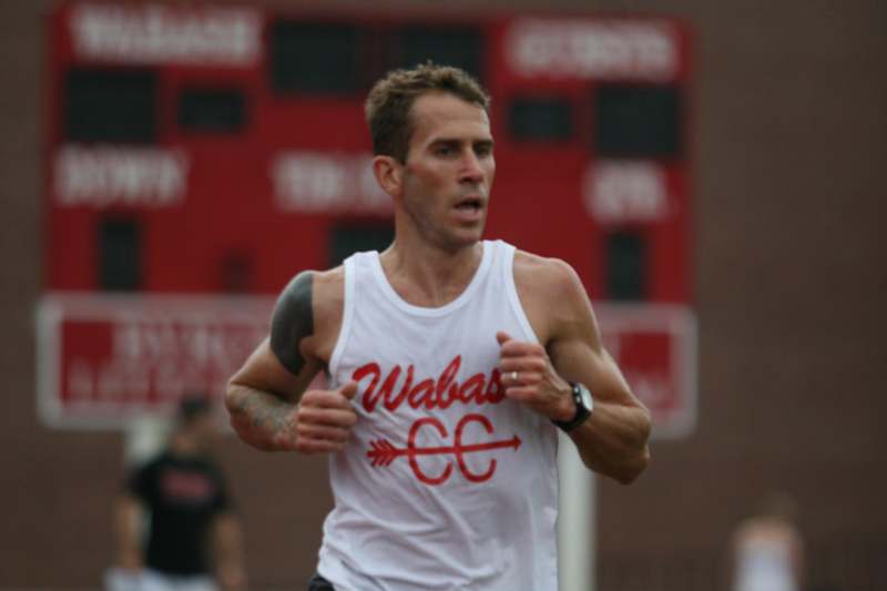 a man running in a white tank top