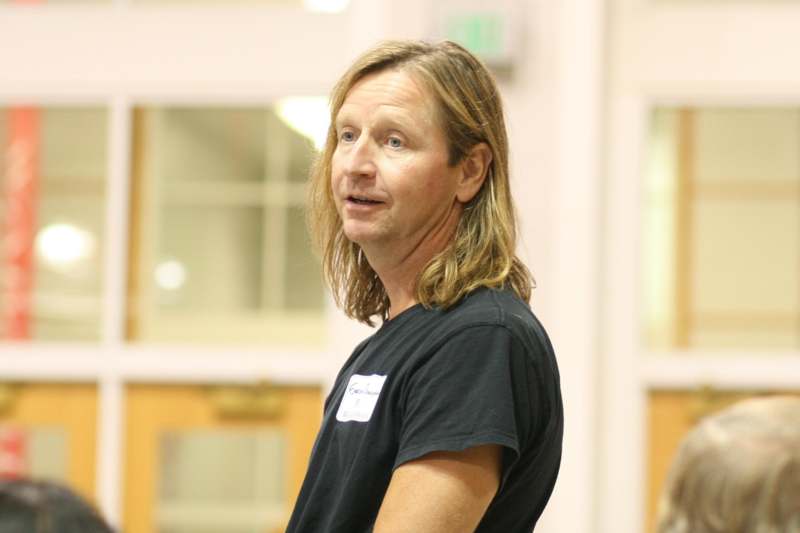 a man with long hair wearing a black shirt
