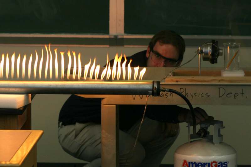 a man in a lab setting with a flame on fire