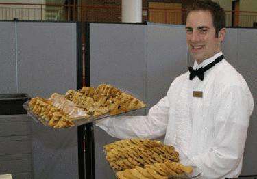 a man holding a tray of cookies