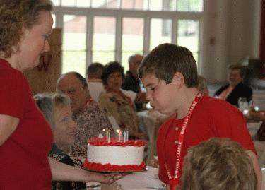 a boy blowing out candles on a cake
