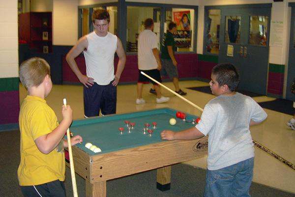 a group of young boys playing pool
