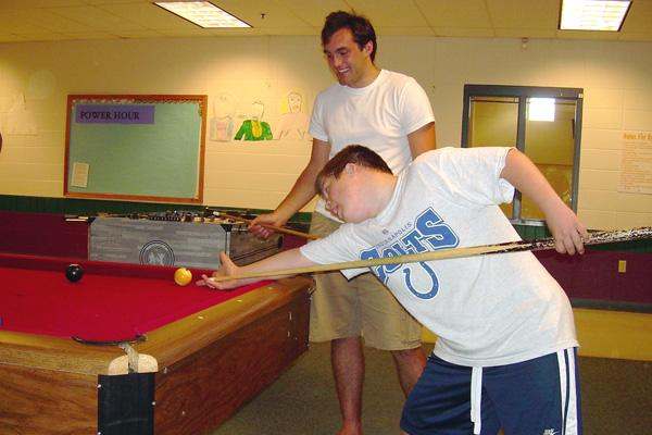 a man playing pool with a stick