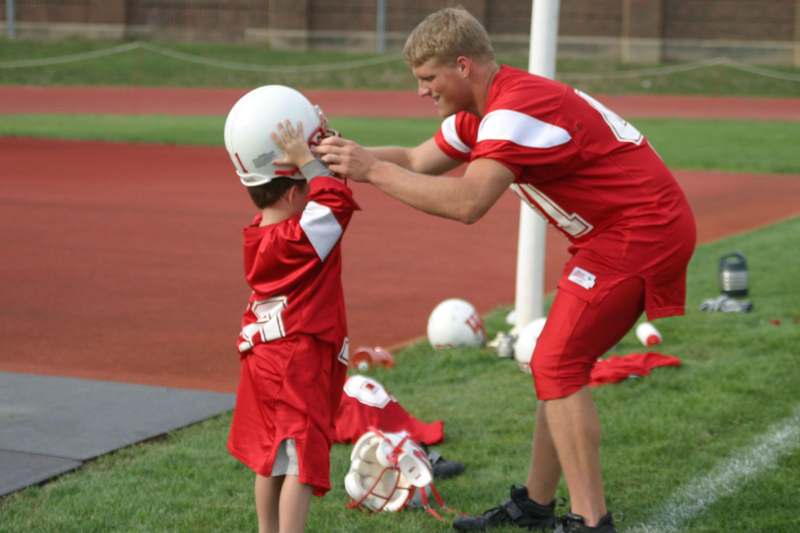 a man helping a boy with a helmet