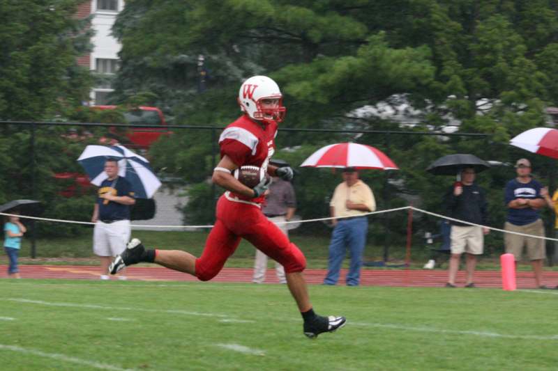 a football player running with a football in his hand
