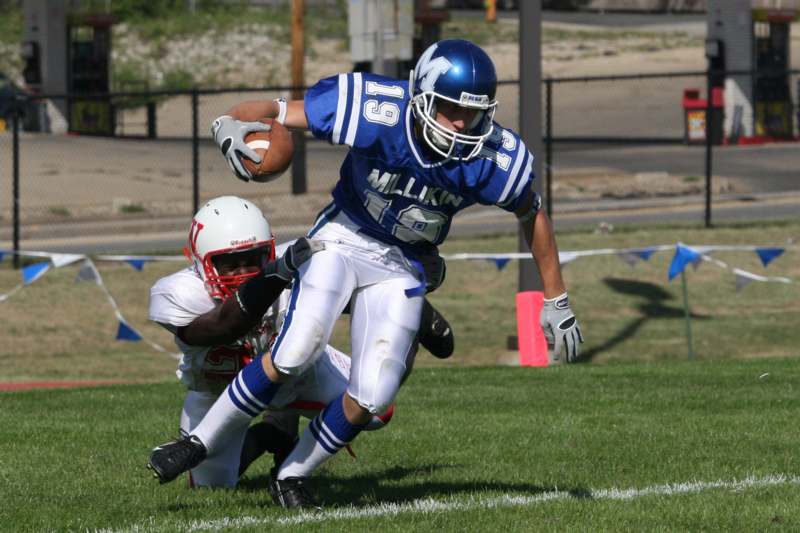 a football player in a blue uniform running with a football